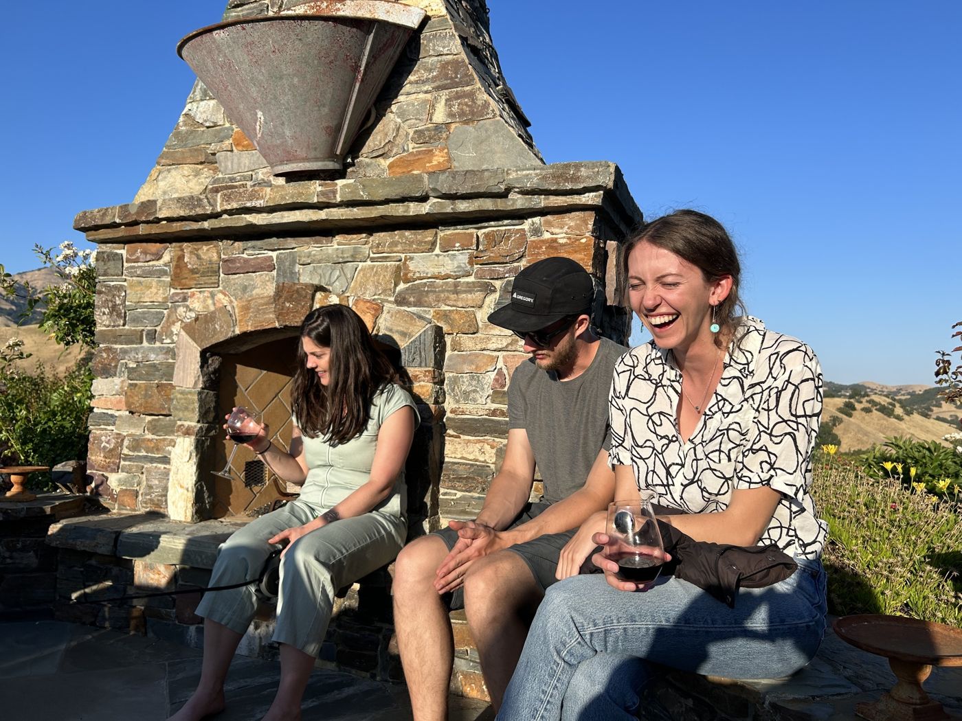 Jack and Danika sharing wine by a stone fireplace